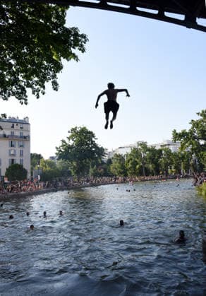 Heatwave Hits at Canal Saint-Martin - Paris Tourists and parisians cool themselves at Canal Saint-Martin as a Heatwave hits in Paris, 40°C expected towards temperature records in France on July 12, 2026. Photo by Alain Apaydin ABACAPRESS.COM Paris France  Copyright: xApaydinxAlain ABACAx