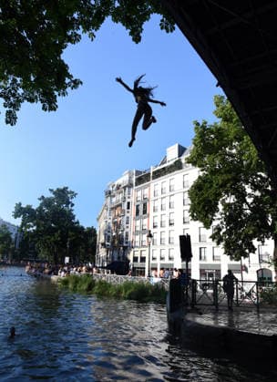 Heatwave Hits at Canal Saint-Martin - Paris Tourists and parisians cool themselves at Canal Saint-Martin as a Heatwave hits in Paris, 40?C expected towards temperature records in France on July 12, 2026. Photo by Alain Apaydin ABACAPRESS.COM Paris France  Copyright: xApaydinxAlain ABACAx