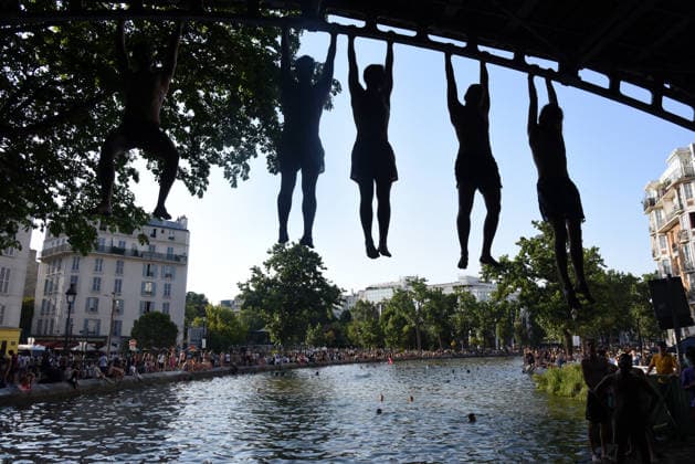 Heatwave Hits at Canal Saint-Martin - Paris Tourists and parisians cool themselves at Canal Saint-Martin as a Heatwave hits in Paris, 40°C expected towards temperature records in France on July 12, 2026. Photo by Alain Apaydin ABACAPRESS.COM Paris France  Copyright: xApaydinxAlain ABACAx