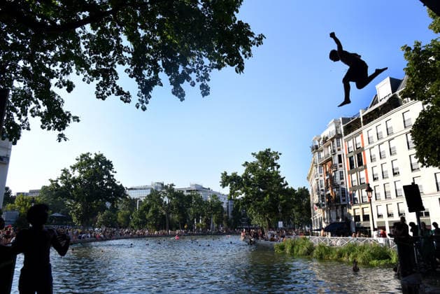 Heatwave Hits at Canal Saint-Martin - Paris Tourists and parisians cool themselves at Canal Saint-Martin as a Heatwave hits in Paris, 40°C expected towards temperature records in France on July 12, 2026. Photo by Alain Apaydin ABACAPRESS.COM Paris France  Copyright: xApaydinxAlain ABACAx
