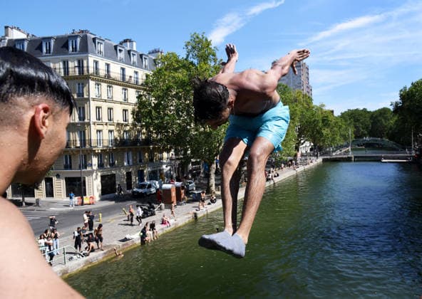 Heatwave Hits at Canal Saint-Martin - Paris Tourists and parisians cool themselves at Canal Saint-Martin as a Heatwave hits in Paris, 40°C expected towards temperature records in France on July 12, 2026. Photo by Alain Apaydin ABACAPRESS.COM Paris France  Copyright: xApaydinxAlain ABACAx