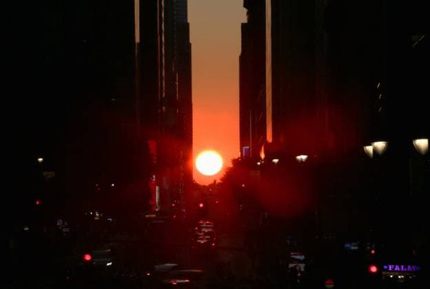 (260713) -- NEW YORK, July 13, 2026 -- This photo taken on July 12, 2026 shows the Manhattanhenge in Manhattan of New York, the United States. The Manhattanhenge refers to the twice-a-year circumstance during which the setting sun aligns precisely with the east-west streets of Manhattan. ) U.S.-NEW YORK-MANHATTANHENGE ZhangxFengguo 