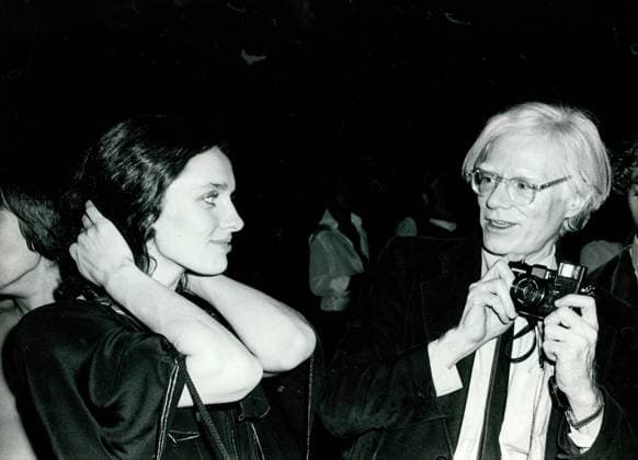 Andy Warhol holds a camera as Margaret Trudeau pulls back her hair Andy Warhol holds a camera as Margaret Trudeau pulls back her hair Copyright: SoniaxMoskowitz 1072_05_Sub04648_47661_H_00016A