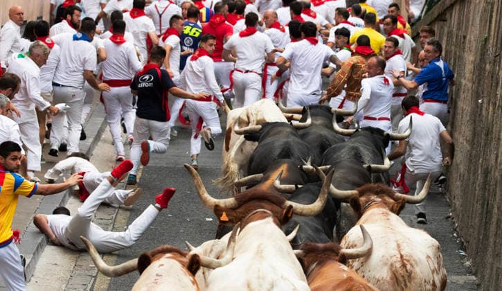 Fighting bulls from the ranch of Miura, stampede up Santo Domingo street in the beginning of the encierro or running-of-the-bulls in the Old City streets in Pamplona, northern Spain, during the Fiesta de San Fermin on Monday, July 13, 2026.  PAM2026071301 JimxHollander