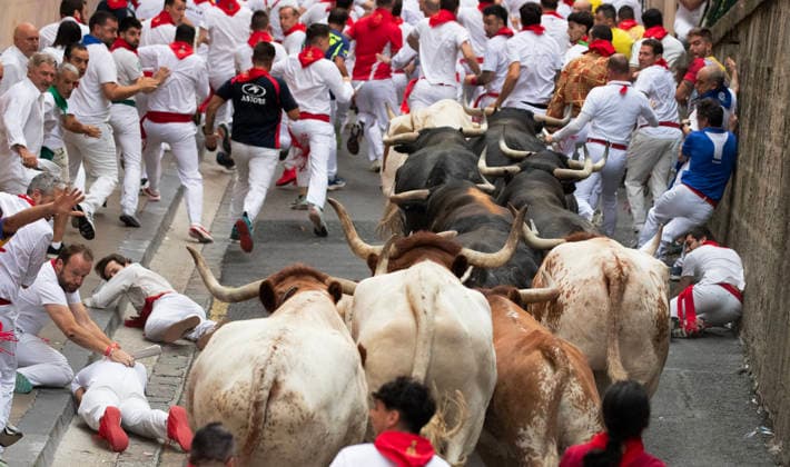 Fighting bulls from the ranch of Miura, stampede up Santo Domingo street in the beginning of the encierro or running-of-the-bulls in the Old City streets in Pamplona, northern Spain, during the Fiesta de San Fermin on Monday, July 13, 2026.  PAM2026071304 JimxHollander