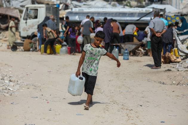 July 13, 2026, Khan Younis, Gaza, Palestine: Palestinians wait in line for hours to collect water from a mobile water tanker in central Khan Younis, southern Gaza Strip. With severe shortages of clean water and soaring summer temperatures, residents continue to struggle to secure their daily water supply as the humanitarian crisis deepens. Khan Younis Palestine - ZUMAq101 20260713_zna_q101_079 Copyright: xRamzixAbuxAmerx