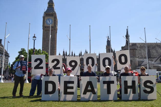 July 13, 2026, London, England, United Kingdom: Activists stage a protest in Parliament Square against the US-UK drug deal. An analysis has suggested that the trade deal could lead to 229,000 excess deaths in England as a result of diverting billions of pounds from essential NHS services to pay for new medicines. London United Kingdom - ZUMAv130 20260713_zip_v130_002 Copyright: xVukxValcicx