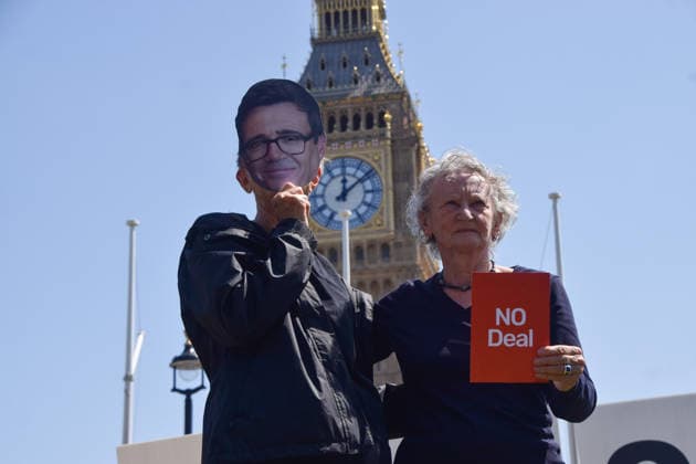 July 13, 2026, London, England, United Kingdom: Baroness JENNY JONES holds a no deal red card next to an activist wearing an Andy Burnham mask during a protest in Parliament Square against the US-UK drug deal. An analysis has suggested that the trade deal could lead to 229,000 excess deaths in England as a result of diverting billions of pounds from essential NHS services to pay for new medicines. London United Kingdom - ZUMAv130 20260713_zip_v130_007 Copyright: xVukxValcicx