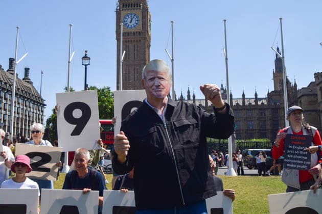 July 13, 2026, London, England, United Kingdom: An activist wearing a Donald Trump mask does a Tump dance during a protest in Parliament Square against the US-UK drug deal. An analysis has suggested that the trade deal could lead to 229,000 excess deaths in England as a result of diverting billions of pounds from essential NHS services to pay for new medicines. London United Kingdom  - ZUMAv130 20260713_zip_v130_015 Copyright: xVukxValcicx