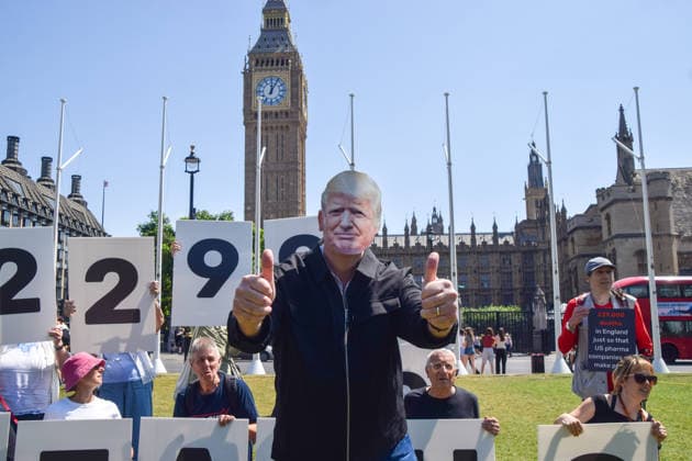 News Bilder des Tages July 13, 2026, London, England, United Kingdom: An activist wearing a Donald Trump mask gives two thumbs up during a protest in Parliament Square against the US-UK drug deal. An analysis has suggested that the trade deal could lead to 229,000 excess deaths in England as a result of diverting billions of pounds from essential NHS services to pay for new medicines. London United Kingdom - ZUMAv130 20260713_zip_v130_014 Copyright: xVukxValcicx