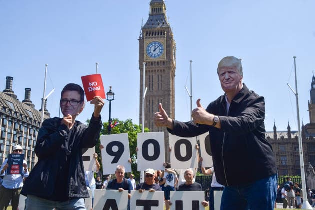 July 13, 2026, London, England, United Kingdom: An activist wearing an Andy Burnham mask shows a no deal red card to an activist wearing a Donald Trump mask during a protest in Parliament Square against the US-UK drug deal. An analysis has suggested that the trade deal could lead to 229,000 excess deaths in England as a result of diverting billions of pounds from essential NHS services to pay for new medicines. London United Kingdom  - ZUMAv130 20260713_zip_v130_019 Copyright: xVukxValcicx