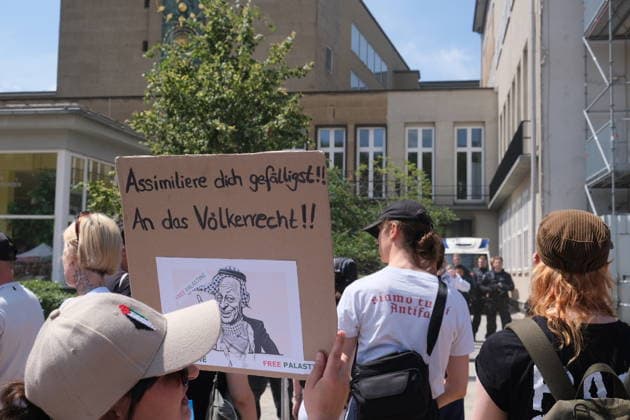 Protesters rally against German Chancellor Merz in Cologne COLOGNE, GERMANY - JULY 13: Demonstrators gather outside the University of Cologne during a protest while German Chancellor Friedrich Merz attends the official inauguration of the Adenauer School of Government in Cologne, Germany, on July 13, 2026. Around 4,000 people joined the demonstration, organized by the university s AStA together with student organizations, trade unions and political groups, criticizing the chancellor s domestic policies, migration policy, social reforms and Germany s support for Israel. Merz participated in the opening ceremony under heightened security while protesters marched and rallied near the university campus. Mouafak Mahmalji Anadolu Cologne German  Copyright: x2026xAnadoluxMouafakxMahmaljix