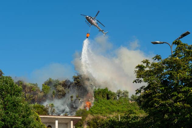 Wildfire erupts near Campi Flegrei volcanic area in Italy POZZUOLI, ITALY - JULY 13: An helicopter drops water over a wildfire on the outer edge of the Solfatara volcanic crater in the Campi Flegrei (Phlegraean Fields) volcanic region in Pozzuoli on July 13, 2026. The fire broke out in the undergrowth and quickly spread in the Pisciarelli area to several car dealerships, causing fuel tanks and tyres to explode. Eliano Imperato Anadolu Pozzuoli Italy. Editorial use only. Please get in touch for any other usage.  Copyright: x2026xAnadoluxElianoxImperatox