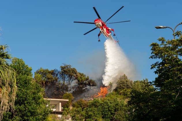 Wildfire erupts near Campi Flegrei volcanic area in Italy POZZUOLI, ITALY - JULY 13: An helicopter drops water over a wildfire on the outer edge of the Solfatara volcanic crater in the Campi Flegrei (Phlegraean Fields) volcanic region in Pozzuoli on July 13, 2026. The fire broke out in the undergrowth and quickly spread in the Pisciarelli area to several car dealerships, causing fuel tanks and tyres to explode. Eliano Imperato Anadolu Pozzuoli Italy. Editorial use only. Please get in touch for any other usage.  Copyright: x2026xAnadoluxElianoxImperatox