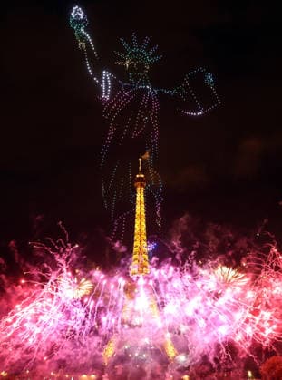 Fireworks and drones light the Eiffel Tower during the Bastille Day celebrations in Paris, France, on Monday, July 13, 2026. The municipality brought the event a day earlier so as to dedicate entirely July 14, 2026 to a national tribute marking the 10th anniversary of the Nice attack when 86 people were killed.  PAR20260713106 MAYAxVIDON-WHITE