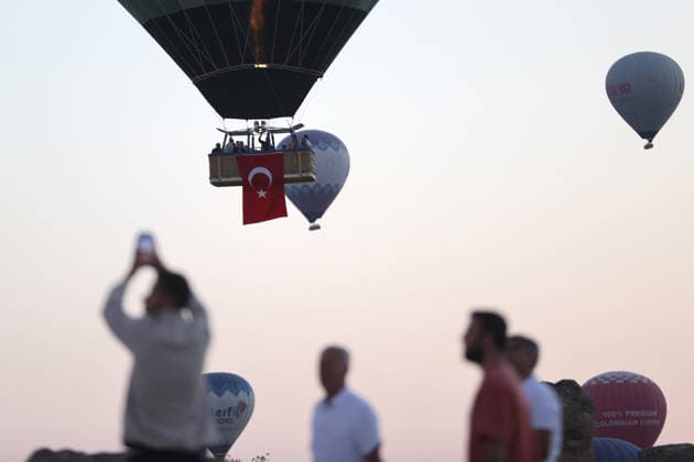 Cappadocia commemorates martyrs of 2016 defeated coup attempt NEVSEHIR, TURKIYE - JULY 14: Hot air balloons take off in Cappadocia carrying Turkish flags and banners featuring photographs of the 253 martyrs to commemorate July 15 Democracy and National Unity Day in Nevsehir, Turkiye on July 14, 2026. As part of the event organized by the Nevsehir Governorship, banners displaying Turkish flags and photographs of the martyrs were attached to the hot air balloons. Behcet Alkan Anadolu Nevsehir Turkey. Editorial use only. Please get in touch for any other usage.  Copyright: x2026xAnadoluxBehcetxAlkanx