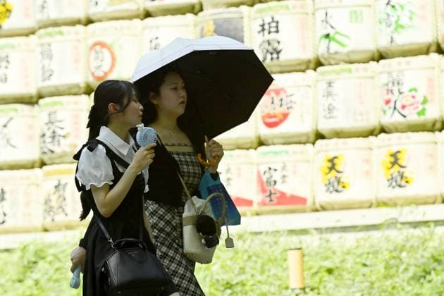 Extreme heat grips Tokyo as temperatures rise across eastern Japan TOKYO, JAPAN - JULY 14 : A visitor uses a parasol while walking past a display of traditional votive plaques at the Meiji Jingu shrine during hot weather in Tokyo, Japan, July 14, 2026. Authorities advised people to avoid prolonged exposure to the sun and drink fluids frequently. David Mareuil Anadolu Tokyo Japan. Editorial use only. Please get in touch for any other usage.  Copyright: x2026xAnadoluxDavidxMareuilx
