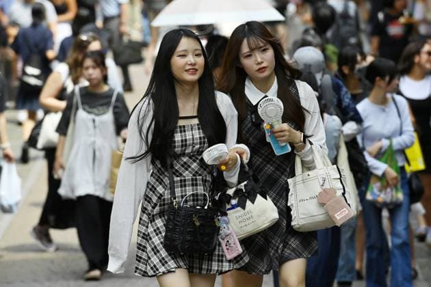 Extreme heat grips Tokyo as temperatures rise across eastern Japan TOKYO, JAPAN - JULY 14 : Young women use handheld fans while walking through the crowded Harajuku district during hot weather in Tokyo, Japan, July 14, 2026. Temperatures in central Tokyo were forecast to reach 34 degrees Celsius. David Mareuil Anadolu Tokyo Japan. Editorial use only. Please get in touch for any other usage.  Copyright: x2026xAnadoluxDavidxMareuilx
