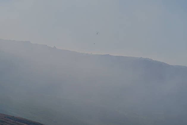 Firefighters battle moorland blaze near Dovestone Reservoir of Manchester SADDLESWORTH, UNITED KINGDOM - JULY 14: A helicopter drops water as firefighters tackle a moorland fire near Dovestone Reservoir in Saddlesworth, Manchester, United Kingdom on 14 July 2026. Loannis Alexopoulos Anadolu Manchester United Kingdom. Editorial use only. Please get in touch for any other usage.  Copyright: x2026xAnadoluxLoannisxAlexopoulosx