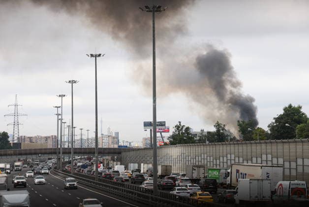 RUSSIA, MYTISHCHI - JULY 14, 2026: Billows of smoke rise from a fire in a residential house behind a sound barrier along a busy motorway. Georgy Chernyshov TASS  95024353