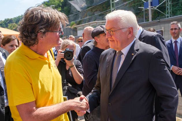 Bundespraesident Frank-Walter Steinmeier (r) spricht mit dem Fotografen mit Ruben Timman vom Museum of Humanity bei einer Ausstellungseroeffnung in Altenahr (Foto vom 14.07.2026). Ueber 60 Portraets und dazu persoenliche Geschichten: Die Freiluftausstellung We AHR strong. Fuenf Jahre, ein neuer Blick rueckt fuenf Jahre nach der Flutkatastrophe die Menschen im Ahrtal in den Fokus. Die Praesentation soll zurueckblicken und nach vorne schauen. Bis zum 24. August sind entlang der Ahr in Altenahr, Bad Neuenahr-Ahrweiler, Sinzig und Schuld die Portraets des Fotografen Ruben Timman vom Museum of Humanity zu sehen. (Siehe epd-Bericht vom 14.07.2026) EDITORIAL USE ONLY *** Federal President Frank Walter Steinmeier speaks with photographer Ruben Copyright: epd-bild GuidoxSchiefer epd-Flutgedenken4-kopieren