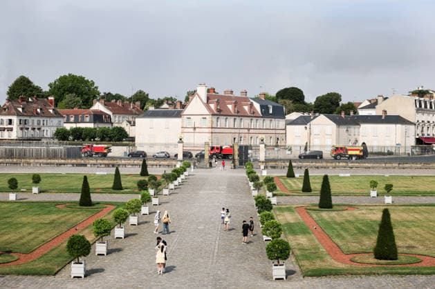 (260714) -- SEINE-ET-MARNE, July 14, 2026 -- Fire trucks pass in front of the Palace of Fontainebleau in Seine-et-Marne, France, on July 14, 2026. French police have detained 59 people across the country in connection with wildfires, including two suspects linked to the blaze in the Fontainebleau forest in Seine-et-Marne department, southeast of Paris, French Interior Minister Laurent Nunez said on Monday. The wildfire in the Fontainebleau forest broke out on Sunday evening and continued to spread on Monday. ) FRANCE-SEINE-ET-MARNE-FONTAINEBLEAU-WILDFIRE WuxHuiwo 