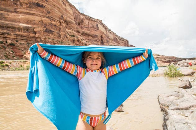 Happy little girl holding up a towel by a river Moab, Utah, United States CR_JDIP260712B-2073104-01 ,model released, Symbolfoto ,property released