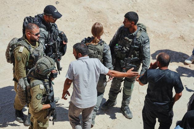 Hebron West Bank Home Demolition Palestinian men speak with Israeli forces during a home demolition operation in Al-Deirat, south of Hebron, occupied West Bank on July 14, 2026. Israeli forces demolish the home of Osama Masaaf on the grounds that it lacked an Israeli-issued building permit, displacing a Palestinian family of eight. Hebron West Bank Palestinian Territories Copyright: xMosabxShawerx