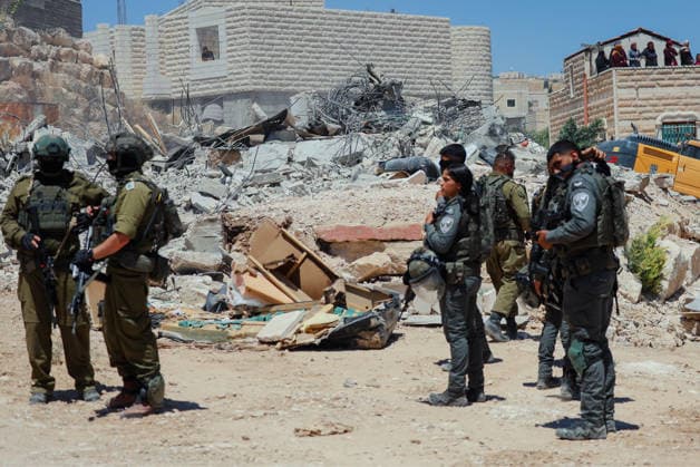Hebron West Bank Home Demolition Israeli forces stand near the rubble of a demolished Palestinian home in Al-Deirat, south of Hebron, occupied West Bank on July 14, 2026. Israeli forces demolish the home of Osama Masaaf on the grounds that it lacked an Israeli-issued building permit, displacing a Palestinian family of eight. Hebron West Bank Palestinian Territories Copyright: xMosabxShawerx