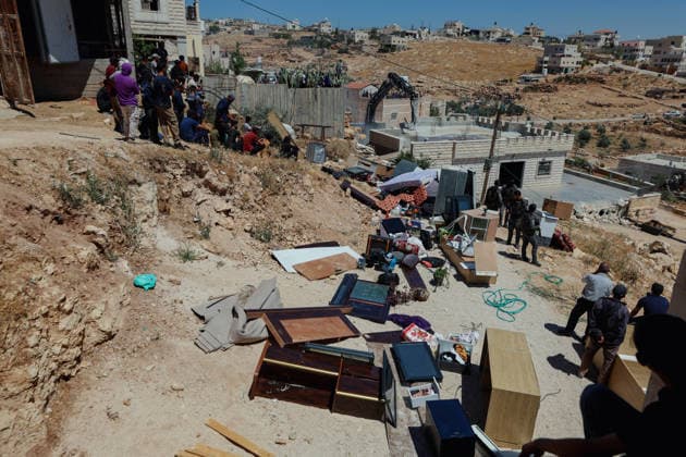 Hebron West Bank Home Demolition Household belongings lie outside the home of Osama Masaaf s family as Palestinian residents and Israeli forces gather during a demolition operation in Al-Deirat, south of Hebron, occupied West Bank on July 14, 2026. Israeli forces demolish the house on the grounds that it lacked an Israeli-issued building permit, displacing the family of eight. Hebron West Bank Palestinian Territories Copyright: xMosabxShawerx