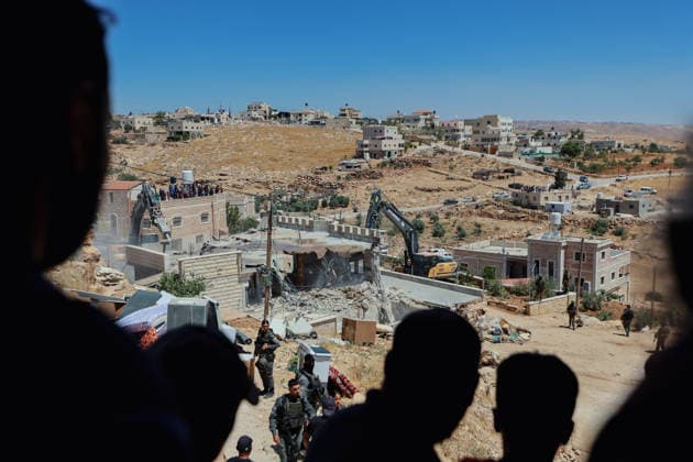 Hebron West Bank Home Demolition Palestinian residents watch as the home of Osama Masaaf s family is demolished in Al-Deirat, south of Hebron, occupied West Bank on July 14, 2026. Israeli forces demolish the house on the grounds that it lacked an Israeli-issued building permit, displacing the family of eight. Hebron West Bank Palestinian Territories Copyright: xMosabxShawerx