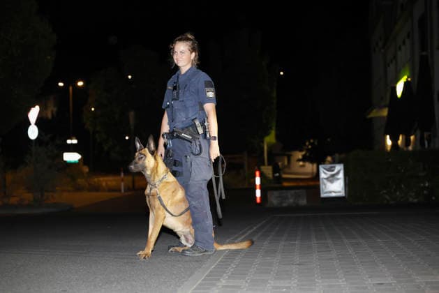 in Polizeihund mit seiner Hundeführerin führt eine systematische Spurensuche am DM-Markt durch. Der Einsatzort dient als Sammelpunkt für die großflächige Fahndung nach dem flüchtigen Verdächtigen. *** A police dog and its handler are conducting a systematic search for evidence at the DM Markt. The scene serves as a staging area for the large-scale manhunt for the fugitive suspect. Copyright: HMBxMedia xHeikoxBecker