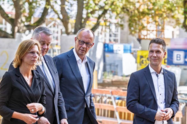 Besuch im Kurpark Bad Neuenahr-Ahrweiler - Fünf Jahre Ahrtalflut Stellvertretende Ministerpräsidentin Rheinland-Pfalz Sabine BÄTZING-LICHTENTHÄLER (SPD), Ministerpräsident Rheinland-Pfalz Gordon SCHNIEDER (CDU), Bundeskanzler Friedrich MERZ (CDU) und Bürgermeister der Stadt Bad Neuenahr-Ahrweiler Pascal ROWALD (CDU) im Gespräch mit Ehrenamtlichen und Gewerbetreibenden im Kurpark Bad Neuenahr-Ahrweiler. Beim Besuch zum fünften Jahrestag der Flutkatastrophe im Ahrtal informierten sie sich über den Stand des Wiederaufbaus. Bad Neuenahr-Ahrweiler Rheinland-Pfalz Deutschland *** Visit to the Bad Neuenahr-Ahrweiler Spa Park: Five Years Since the Ahr Valley Floods. Sabine BÄTZING LICHTENTHÄLER (SPD), Deputy Minister-President of Rhinelan Copyright: xMarcxJohnx