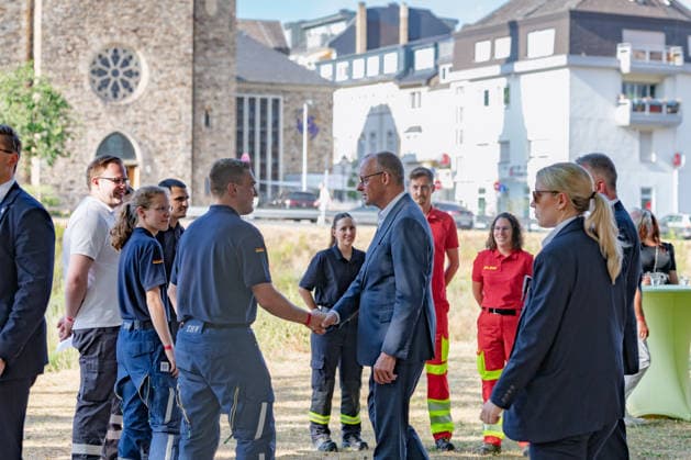 Besuch im Kurpark Bad Neuenahr-Ahrweiler - Fünf Jahre Ahrtalflut Bundeskanzler Friedrich MERZ und Ministerpräsident Gordon SCHNIEDER im Gespräch mit Ehrenamtlichen und Gewerbetreibenden im Kurpark Bad Neuenahr-Ahrweiler. Beim Besuch zum fünften Jahrestag der Flutkatastrophe im Ahrtal informierten sie sich über den Stand des Wiederaufbaus. Bad Neuenahr-Ahrweiler Rheinland-Pfalz Deutschland *** Visit to the Spa Park in Bad Neuenahr-Ahrweiler: Five Years Since the Ahr Valley Floods. Federal Chancellor Friedrich MERZ and Minister President Gordon SCHNIEDER speaking with volunteers and business owners in the Spa Park in Bad Neuenahr-Ahrweiler. During their visit to mark the fifth anniversary of the flood disaster in the AhrValley, they wer Copyright: xMarcxJohnx