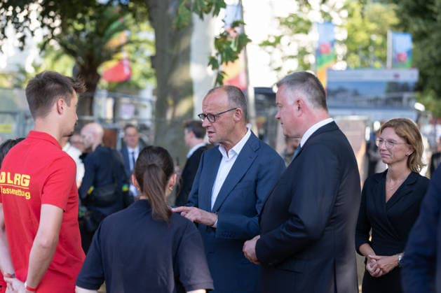 Besuch im Kurpark Bad Neuenahr-Ahrweiler - Fünf Jahre Ahrtalflut Bundeskanzler Friedrich MERZ und Ministerpräsident Gordon SCHNIEDER im Gespräch mit Ehrenamtlichen und Gewerbetreibenden im Kurpark Bad Neuenahr-Ahrweiler. Beim Besuch zum fünften Jahrestag der Flutkatastrophe im Ahrtal informierten sie sich über den Stand des Wiederaufbaus. Bad Neuenahr-Ahrweiler Rheinland-Pfalz Deutschland *** Visit to the Spa Park in Bad Neuenahr-Ahrweiler: Five Years Since the Ahr Valley Floods. Federal Chancellor Friedrich MERZ and Minister President Gordon SCHNIEDER speaking with volunteers and business owners in the Spa Park in Bad Neuenahr-Ahrweiler. During their visit to mark the fifth anniversary of the flood disaster in the AhrValley, they wer Copyright: xMarcxJohnx