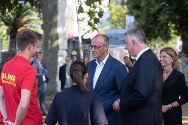 Besuch im Kurpark Bad Neuenahr-Ahrweiler - Fünf Jahre Ahrtalflut Bundeskanzler Friedrich MERZ und Ministerpräsident Gordon SCHNIEDER im Gespräch mit Ehrenamtlichen und Gewerbetreibenden im Kurpark Bad Neuenahr-Ahrweiler. Beim Besuch zum fünften Jahrestag der Flutkatastrophe im Ahrtal informierten sie sich über den Stand des Wiederaufbaus. Bad Neuenahr-Ahrweiler Rheinland-Pfalz Deutschland *** Visit to the Spa Park in Bad Neuenahr-Ahrweiler: Five Years Since the Ahr Valley Floods. Federal Chancellor Friedrich MERZ and Minister President Gordon SCHNIEDER speaking with volunteers and business owners in the Spa Park in Bad Neuenahr-Ahrweiler. During their visit to mark the fifth anniversary of the flood disaster in the AhrValley, they wer Copyright: xMarcxJohnx