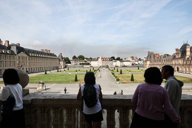(260715) -- BEIJING, July 15, 2026 -- Tourists visit the Palace of Fontainebleau in Seine-et-Marne, France, as smoke from a wildfire is seen in the distance, on July 14, 2026. French police have detained 59 people across the country in connection with wildfires, including two suspects linked to the blaze in the Fontainebleau forest in Seine-et-Marne department, southeast of Paris, French Interior Minister Laurent Nunez said on Monday. The wildfire in the Fontainebleau forest broke out on Sunday evening and continued to spread on Monday. ) XINHUA PHOTOS OF THE DAY WuxHuiwo 