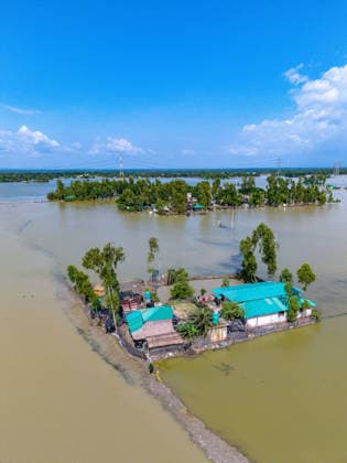 Aftermath Of Floodwaters In Chattogram A drone shot captures homesteads with distinctive green tin roofs isolated like small islands amid vast stretches of floodwater in Banshkhali, Chattogram, Bangladesh, on July 14, 2026. Although flood waters in Banshkhali and Satkania in Chittagong are slowly receding, many areas remain knee-deep in water. As the water recedes, collapsed mud houses, damaged structures, destroyed brick kilns and severely damaged agricultural land are becoming visible, displacing thousands of people. Chattogram Bangladesh  Copyright: xZakirxHossainx originalFilename: hossain-notitle260714_np0LK.jpg