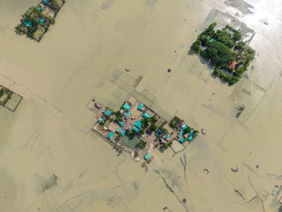 Aftermath Of Floodwaters In Chattogram A top-down drone photograph shows a localized cluster of homes trapped within a vast expanse of floodwater, reflecting the afternoon sun in Banshkhali, Chattogram, Bangladesh, on July 14, 2026. Flood waters in Banshkhali and Satkania in Chittagong are slowly receding, revealing collapsed mud houses, damaged structures, destroyed brick kilns and severely damaged agricultural land. The flooding has displaced thousands of people. Chattogram Bangladesh  Copyright: xZakirxHossainx originalFilename: hossain-notitle260714_npuEa.jpg