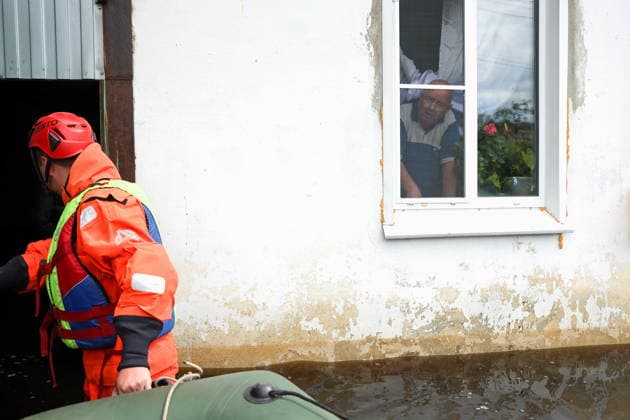 RUSSIA, SVERDLOVSK REGION - JULY 15, 2026: An emergency worker enters a house in the flood-hit village of Zaikovo, southwest of Irbit. Donat Sorokin TASS  95063759