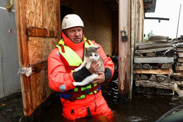 RUSSIA, SVERDLOVSK REGION - JULY 15, 2026: An emergency worker rescues a cat from the flood-hit village of Zaikovo, southwest of Irbit. Donat Sorokin TASS  95063760
