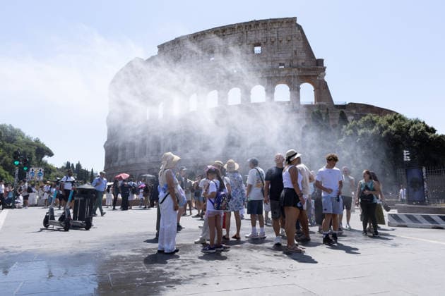 IPA86702492 - Tourists seek relief from the heat under the misting spray in front of the Colosseum in Rome  Copyright: xMatteoxNardonex xx 86702492
