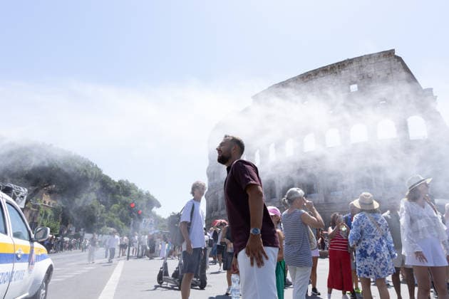 IPA86702494 - Tourists seek relief from the heat under the misting spray in front of the Colosseum in Rome  Copyright: xMatteoxNardonex xx 86702494