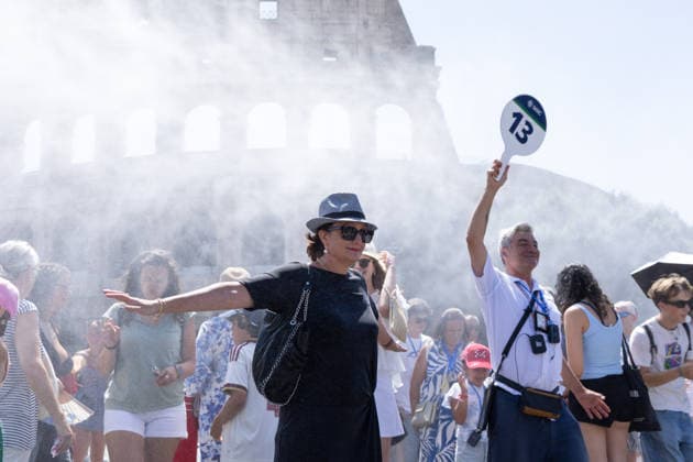 IPA86702495 - Tourists seek relief from the heat under the misting spray in front of the Colosseum in Rome  Copyright: xMatteoxNardonex xx 86702495