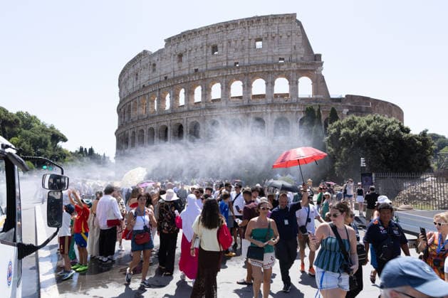 IPA86702497 - Tourists seek relief from the heat under the misting spray in front of the Colosseum in Rome  Copyright: xMatteoxNardonex xx 86702497