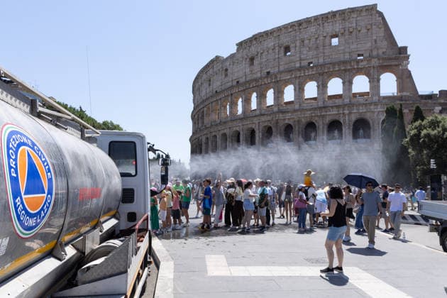 IPA86702499 - Tourists seek relief from the heat under the misting spray in front of the Colosseum in Rome  Copyright: xMatteoxNardonex xx 86702499