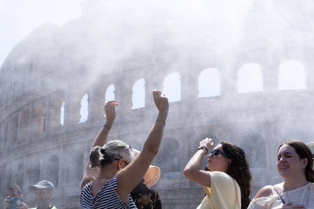 IPA86702501 - Tourists seek relief from the heat under the misting spray in front of the Colosseum in Rome  Copyright: xMatteoxNardonex xx 86702501