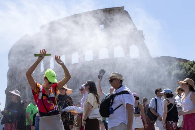 IPA86702503 - Tourists seek relief from the heat under the misting spray in front of the Colosseum in Rome  Copyright: xMatteoxNardonex xx 86702503