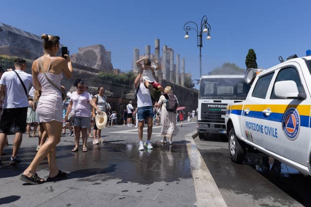 IPA86702511 - Tourists seek relief from the heat under the misting spray in front of the Colosseum in Rome  Copyright: xMatteoxNardonex xx 86702511