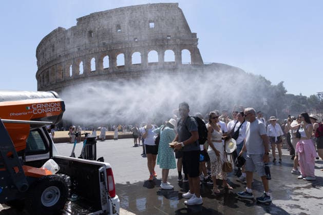 IPA86702513 - Tourists seek relief from the heat under the misting spray in front of the Colosseum in Rome  Copyright: xMatteoxNardonex xx 86702513